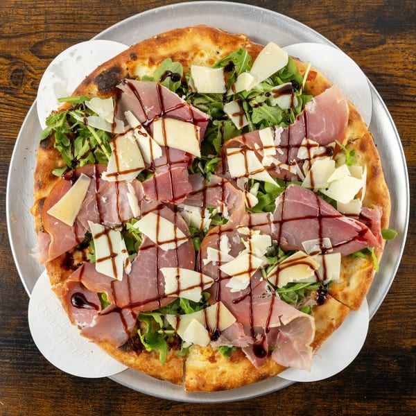 Oak Pantry Deli n' Pizza's prosciutto and arugula pizza, drizzled with balsamic glaze.