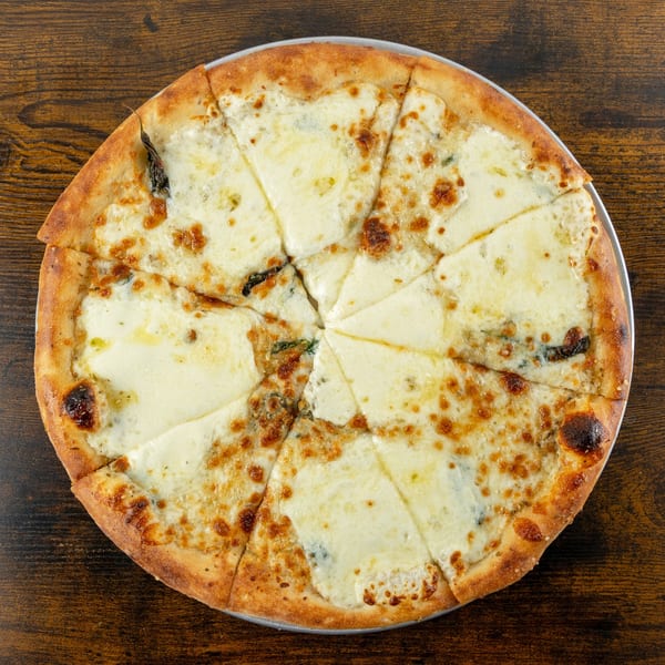 Overhead view of a white pizza with a golden crust, sliced into eight pieces on a wooden table.