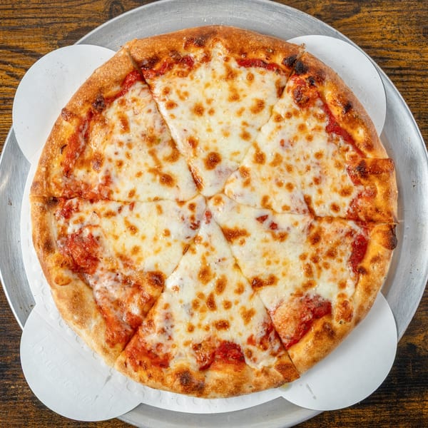 A whole cheese pizza, cut into slices, on a metal tray with white paper liners.