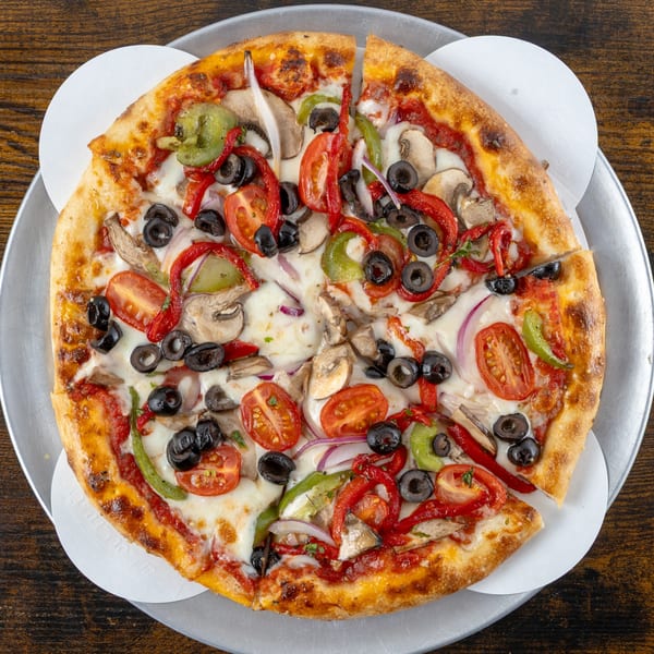 A freshly baked Oak Pantry Deli n' Pizza veggie pizza with olives, peppers, mushrooms, and tomatoes.